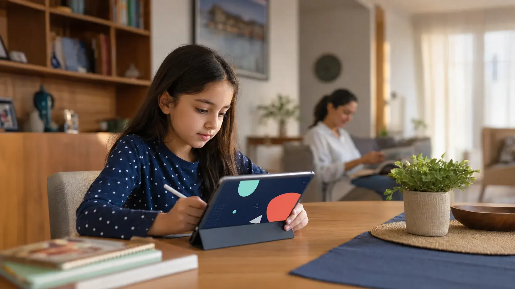 Evde tablet üzerinden çalışan kumral bir öğrenci